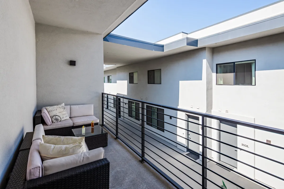 This image displays a serene balcony seating area with a clear sky backdrop. The setup is perfect for guests to gather, relax, and enjoy drinks or quiet reading outdoors, capturing the essence of group flexibility and social options at Thunderbird.
